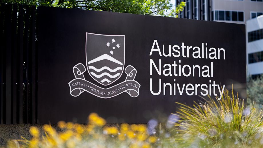 ANU signage surrounded by plants and foliage.