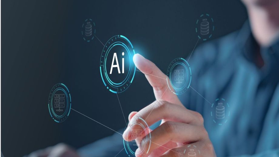 A man seated at a computer uses his index finger to pint at the animated characters "Ai".