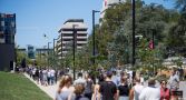 A crowd of people walk along University Avenue at the Australian National University.